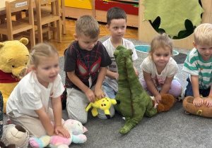 Dzieci ćwiczą na misiach uciski klatki piersiowej.