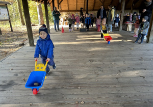 Chłopcy biegną z taczkami.