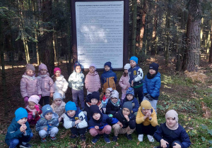 Pięciolatki pozują do zdjęcia przy tablicy.