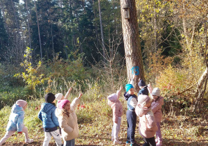 Przedszkolaki wskazują znalezioną lęgową budkę ptaków.