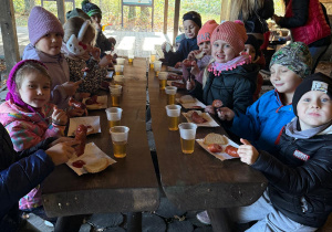 Dzieci zjadają wspólnie posiłek.