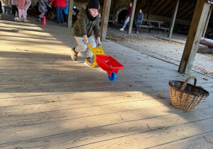 Chłopiec biegnie z taczką.