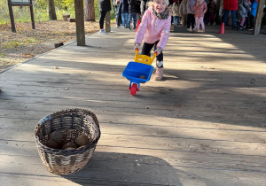 Dziewczynka prowadzi taczkę.