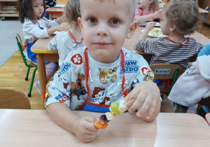 Chłopiec nabija owoce na drewniany patyczek