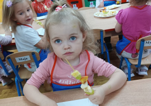 Dziewczynka pokazuje swój owocowy szaszłyk