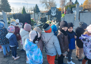 Dzieci stoją przed grobem poległych w walce o naszą ojczyznę.