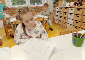 Dziewczynka wycina nożyczkami.