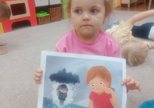 Dziewczynka pokazuje ilustrację do opowiadania