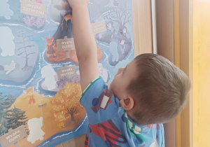 Chłopiec przykleja postać Markotka do Krainy Emocji