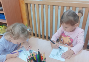 Dziewczynki kolorują postać Markotka