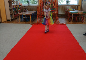 01. Dziewczynka w stroju Jednorożca idzie po czerwonym dywanie.