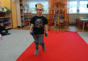 06. Chłopiec idzie po czerwonym dywanie.