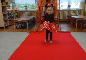 07. Dziewczynka w stroju Myszki Miki idzie po czerwonym dywanie.