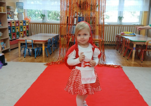 09. Dziewczynka w stroju Czerwonego Kapturka idzie po czerwonym dywanie.