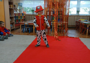 13. 12. Chłopiec na czerwonym dywanie.