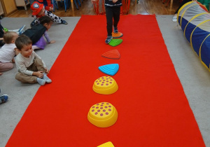 32. Chłopiec idzie po kamieniach.