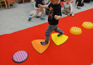 34. Chłopiec idzie po kamieniach.