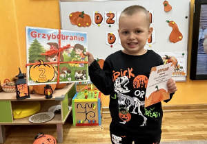 Chłopiec trzyma nagrodę i dyplom.