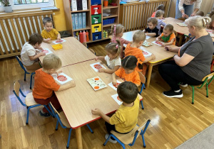 Dzieci malują farbami.