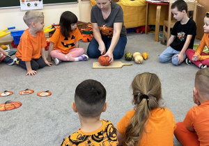 Dzieci siedzą na dywanie.