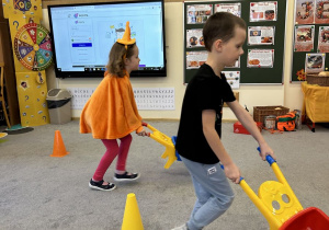 Dzieci biegną z dynią w taczce.