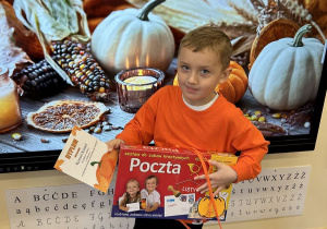 Chłopiec trzyma nagrodę i dyplom.