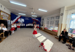 Dziewczynka śpiewa piosenkę do mikrofonu.