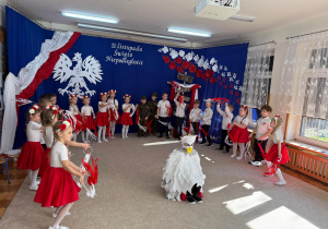 Dzieci śpiewają i tańczą ze wstążkami.