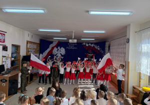 Dzieci tańczą z serduszkami i flagami.