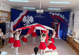 Dziewczynki podrzucają materiały do góry.