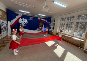 Dziewczynki trzymają materiały do tańca.