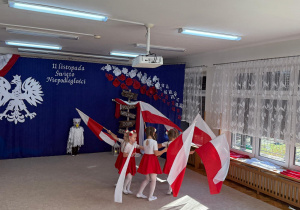 Dziewczynki tańczą z flagami.