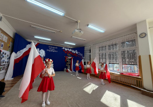 Dziewczynki tańczą z flagami.