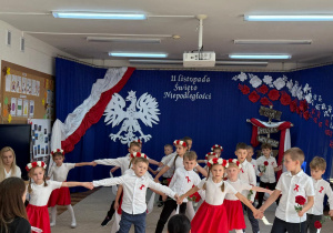 Dzieci tańczą w rzędach.