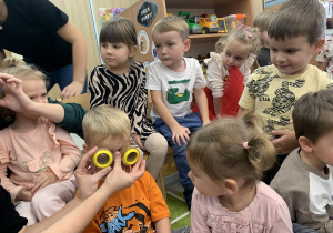 Chłopiec przykłada lupy do oczu, które wyglądają jak okulary.