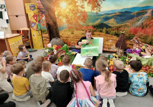 Dzieci oglądają ilustrację o życiu mrówek.