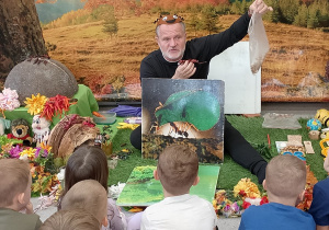Prowadzący pokazuje dzieciom, jak mrówki przenoszą swoje zdobycze.
