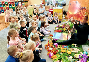 Dzieci oglądają ilustracje z życia mrówki.