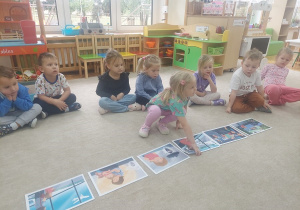 Dziewczynka szuka ilustracji do historyjki obrazkowej.