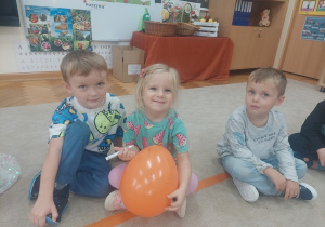 Dziewczynka maluje mazakiem na balonie.