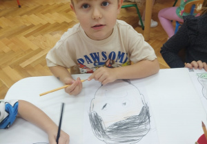 Chłopiec maluje swoje emocje.