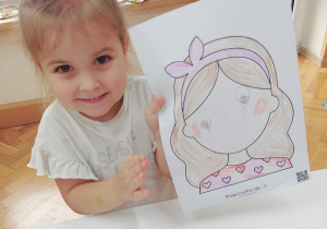 Dziewczynka pokazuje swój obrazek.