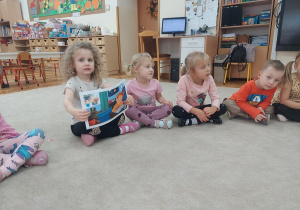 Dziewczynka prezentuje ilustracje do opowiadania.