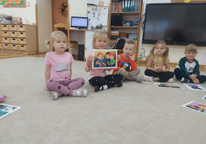 Dziewczynka prezentuje obrazek do historyjki obrazkowej.