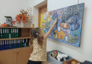 Dziewczynka szuka na tablicy Wyspy Zdziwienia.