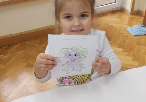 Dziewczynka prezentuje efekty swojej pracy.