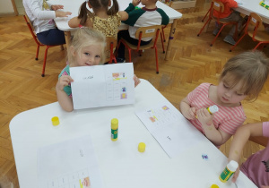 Dziewczynka pokazuje swoją książeczkę.