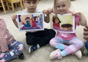 Czterolatki pokazują ilustracje do nowo poznanego Czuciaka.