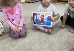 Dziewczynka pokazuje obrazek dziewczynki z wysłuchanego tekstu.