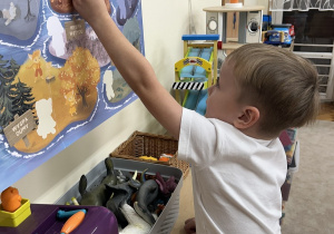 Chłopiec przywiesza postać Gniewka do tablicy.